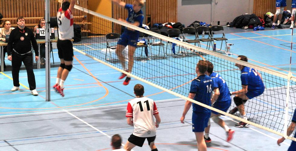 En spiller fra BK Troms&oslash; smasher en volleyball forbi en spiller fra OSI som pr&oslash;ver &aring; blokke.